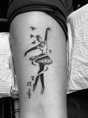 Illustrative tattoo by Ronny East featuring a graceful ballerina surrounded by music notes and birds, symbolizing freedom and beauty.