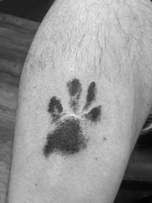 Blackwork and dotwork animal paw print tattoo by Ronny East, honoring a beloved pet.