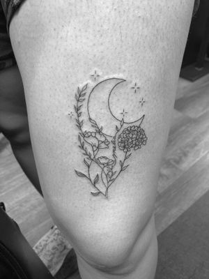 Capture the beauty of the moon and flower in this exquisite fine line and illustrative tattoo by Ronny East.