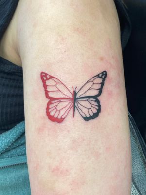 Experience the beauty of a red illustrative butterfly tattoo crafted by talented artist Ronny East.