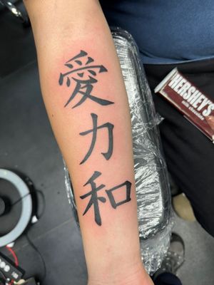 Get a stunning blackwork Japanese kanji tattoo by Ronny East, combining tradition with modern lettering style.
