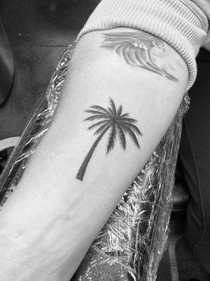 Embrace the island life with this illustrative palm tree tattoo by Ronny East. Perfect for those who crave sunny days and beach breezes.