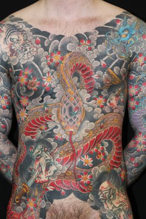 Experience the power of the snake, tiger, and dragon in this stunning Japanese tattoo by renowned artist Stewart Robson. Bold colors and intricate details await.