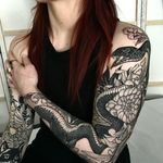 Intricate blackwork design featuring a snake and flower motif, expertly executed by tattoo artist Giada Knox.