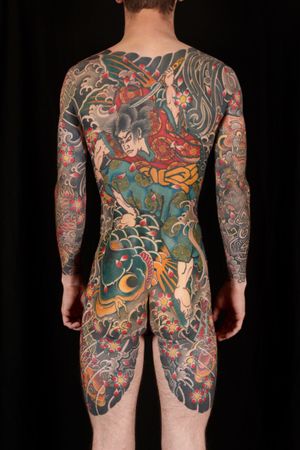 Immerse yourself in the ancient world of Japan with this stunning back piece featuring a fierce samurai and majestic koi fish, masterfully inked by Stewart Robson.