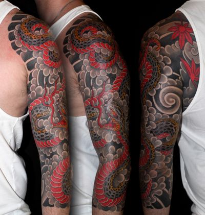 Get inked by the master artist Stewart Robson with this striking Japanese style tattoo featuring a fierce snake entwined in smoke.
