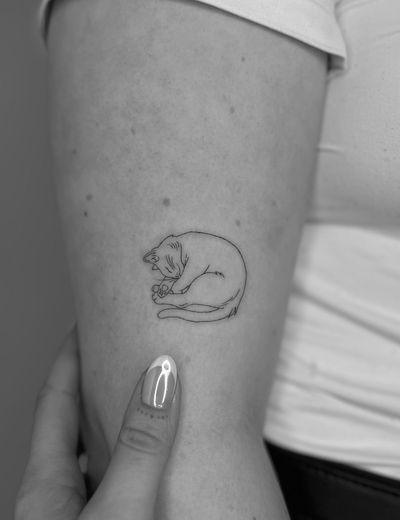 A fine line tattoo of a delicate cat, Meg's art captures the essence of a beloved pet.