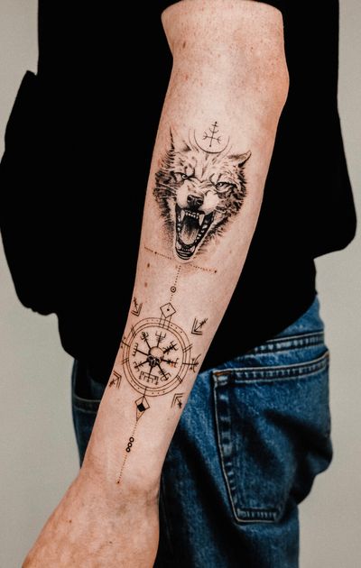 Explore the mystical world of Norse mythology with this stunning fine line and geometric tattoo of a wolf intertwined with runic symbols. By talented artist Gabriele Edu.