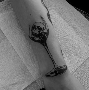 Illustrative tattoo featuring a skull trapped inside a glass object, designed by Oliver Soames.