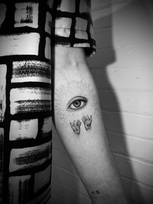 Experience the intricate artistry of Georgina's micro-realism tattoo featuring a mesmerizing eye and hands design.