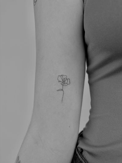 Experience the artistry of Ruth Hall with this stunning fine line tattoo featuring a single line flower motif. Embrace elegance and beauty in every detail.