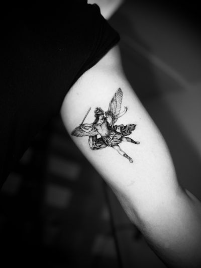 Capture the divine beauty with this black and gray tattoo of an angel, intricately designed by tattoo artist Georgina.