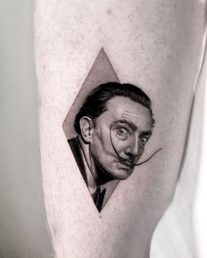 Experience the surreal with this black and gray realism tattoo by expert artist Jay Soze. Capturing the essence of Salvador Dali's iconic portrait.