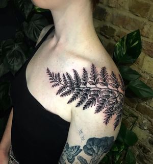 Explore the beauty of nature with this intricate blackwork tattoo featuring a realistic branch and leaf design, expertly done by artist Giada Knox.