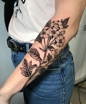 Get a stunning blackwork illustrative tattoo of a flower and branch design by the talented artist Giada Knox.