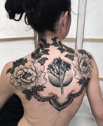 Get lost in the intricate blackwork design of nature-inspired tree, flower, and pattern elements by Giada Knox.