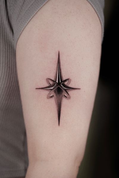 Experience micro-realism with Gloria Gu's black and gray metallic star tattoo.