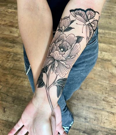Explore the intricate blackwork design of a butterfly and flower by talented artist Giada Knox. A perfect balance of nature and artistry.