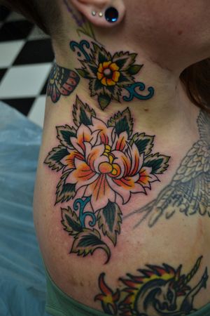 Experience the timeless beauty of traditional tattoo art with a stunning flower design by the talented artist Liam Harbison.