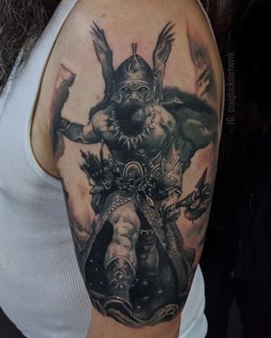 Get a stunning black and gray Viking tattoo that captures the fierce warrior spirit, created with expert precision by tattoo artist Craig Hicks.