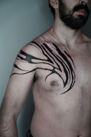 Experience the fusion of ancient tribal motifs with futuristic cyber sigilism in this mesmerizing blackwork tattoo by the talented Dominga Longo.