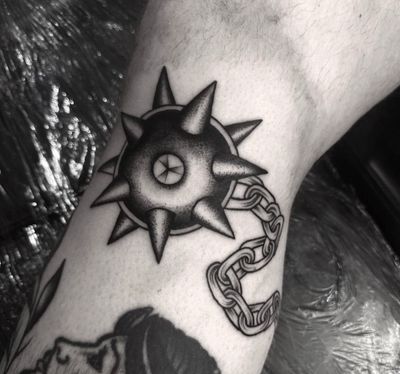 Admire the intricately detailed black and gray morning star mace tattoo expertly done by artist Sophia Hayes.