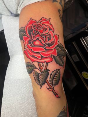 Get inked with a classic traditional rose tattoo done by the talented artist Barney Coles. Timeless beauty and expert craftsmanship guaranteed.