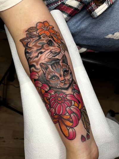 Experience the whimsical blend of traditional and neo traditional styles in this stunning cat and flower pet tattoo by Barney Coles.