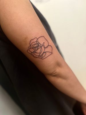 Elegantly crafted fine line tattoo featuring a single line flower motif by the talented artist, Miss Vampira.