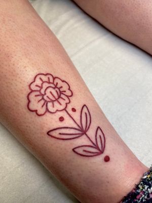Get a beautifully detailed illustrative flower tattoo in brown ink, skillfully done by artist Claudia Vicente.