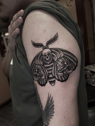 Get inked with a haunting traditional tattoo of a moth symbolizing death, created by the talented artist Barney Coles.