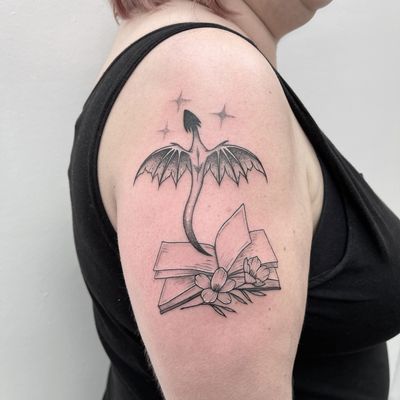 A stunning dotwork tattoo combining a dragon and a book, expertly executed by the talented artist Chris Harvey.