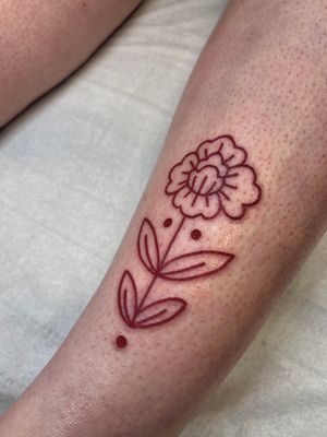 Elegant flower tattoo in brown ink, beautifully crafted by artist Claudia Vicente.