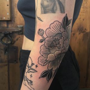 Experience the timeless beauty of a peony flower with this stunning illustrative tattoo by Claudia Vicente. A true work of art on your skin.