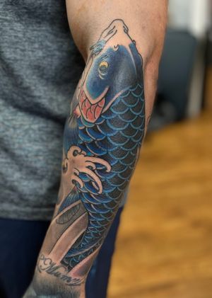 Stunning koi fish tattoo by Martin Kirke, featuring intricate Japanese design elements. A symbol of strength and perseverance.