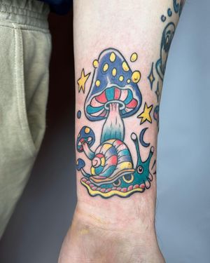 Get inked with this charming illustrative design by Jonathan Glick, featuring a playful snail and a mystical mushroom.