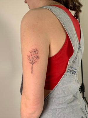 Elegantly crafted by Chloe Hartland, this fine line tattoo features a dainty flower motif in stunning dotwork style.