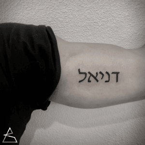 Hebrew "Daniel". black and grey realism tattoo