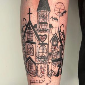 Get bewitched by Zanzi La Vey's stunning illustrative tattoo featuring a bat flying over a haunted mansion.
