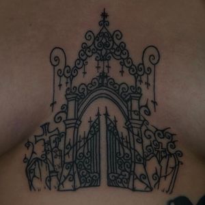 Experience a hauntingly beautiful illustrative tattoo of a cemetery gate, expertly crafted by Zanzi La Vey.