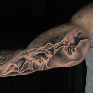 Get inspired by this stunning black and gray realism tattoo of creation hands by the talented artist Craig Hicks.