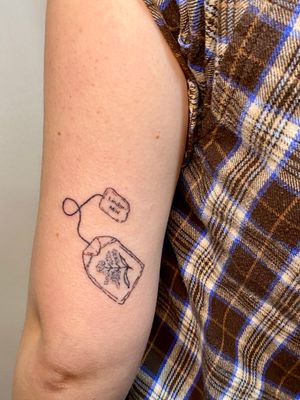 Experience the intricate beauty of dotwork and handpoke techniques in this unique tea bag tattoo by Charlotte Pokes.
