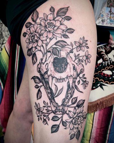 Stunning illustrative tattoo by artist Hannah Senoj featuring a unique combination of flowers and skulls. Truly a masterpiece!
