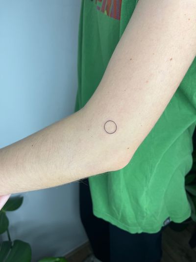 Get a sleek and intricate fine line tattoo of a geometric circle done by the talented artist Michelle Harrison.
