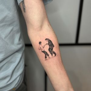 Get a sleek black and gray tattoo of a iconic Pulp Fiction scene done by the talented artist Tas Kal.