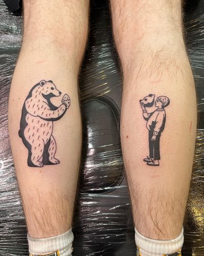 Illustrative tattoo by Dave Norman featuring a bear, a kid, and a mask motif. Bold and detailed blackwork design.