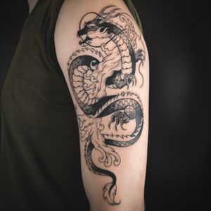 Experience the power and beauty of a dragon in this illustrative tattoo, expertly crafted by the talented artist Jenny Dubet.