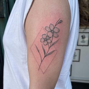 Elegantly blending fine lines and geometric shapes, Chris Harvey's illustrative flower tattoo is a modern and sophisticated choice for those seeking a unique and stylish design.