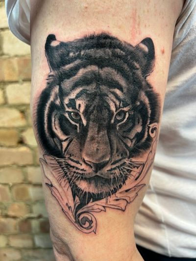 Capture the power and beauty of the majestic tiger with this stunning black and gray realism tattoo by Misa.