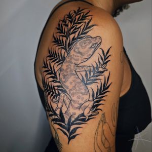 Illustrative tattoo featuring a fern and salamander design by AmaaNitaa. Bold blackwork style.